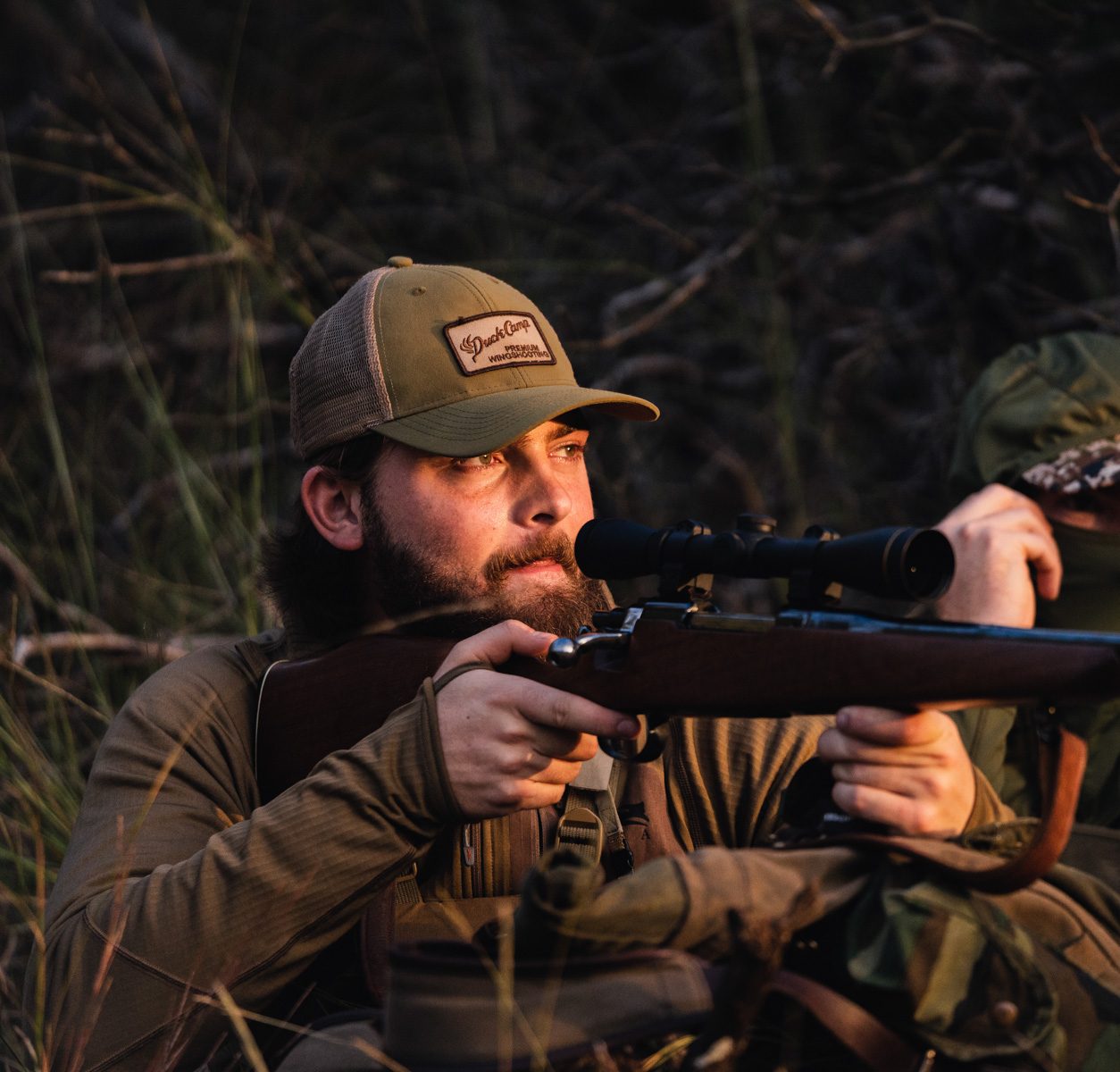 A hunter walking the field with a bow
